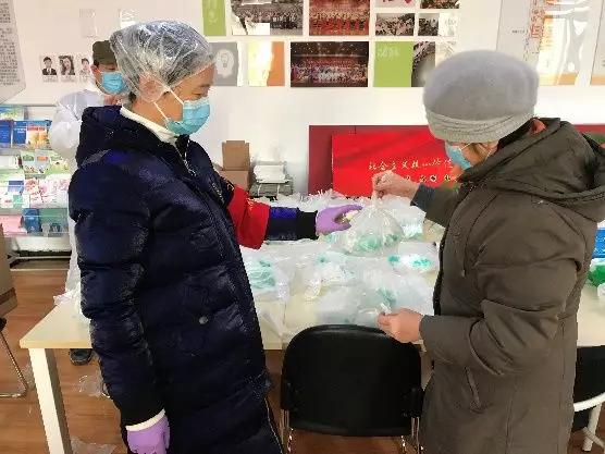為樓棟分發(fā)口罩，并為包裝袋消毒